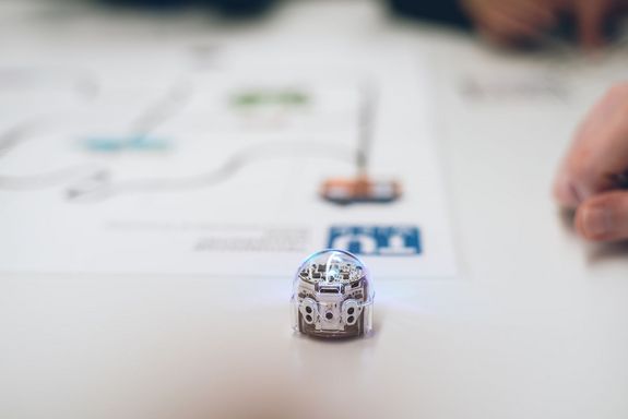 small robot and paper with TU logo