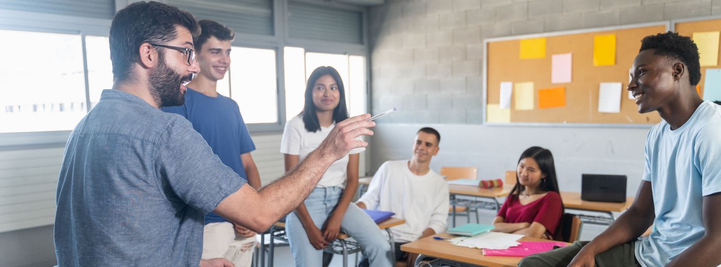 Lehrender im Gespräch mit Studierenden