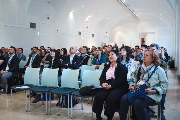View of the audience in a white room with a vaulted ceiling.
