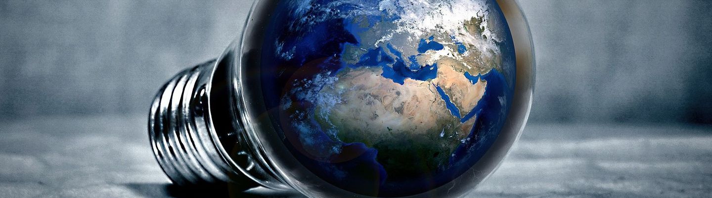 The globe is in a light bulb lying on a grey cloth.