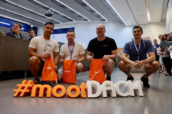 Menschen hockend hinter moot dach Schriftzug 3