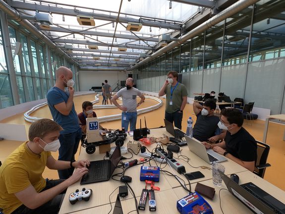 people at a table, with tools and laptops