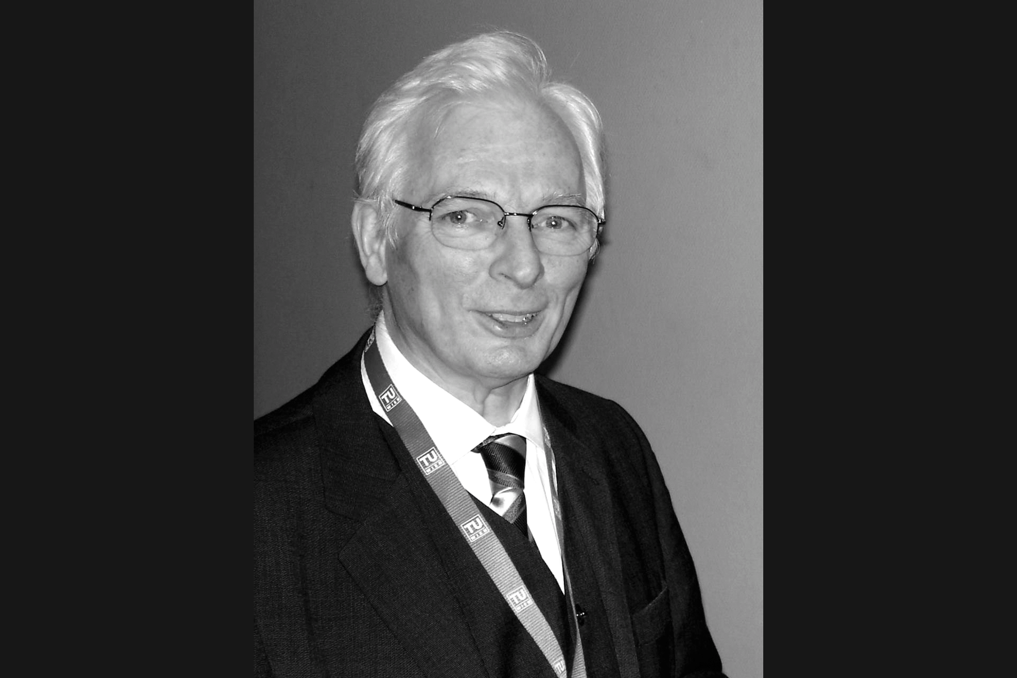 Porträtbild von Prof. Springer in Schwarz-Weiß. Er hat weiße kurze Haare und trägt ein Jackett mit weißem Hemd.