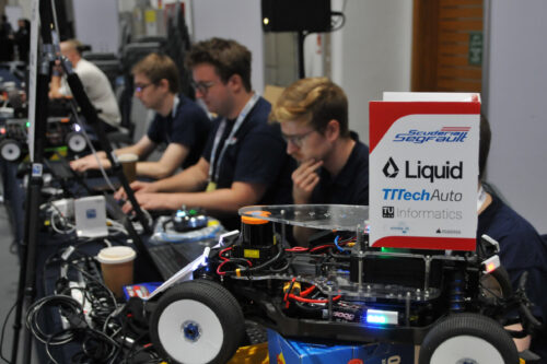 Team working to configure the car, with race car in the front